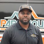 Professional contractor wearing Paramount branded polo shirt and cap smiling at camera