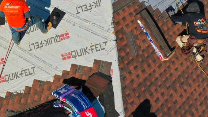 Roofers installing shingles on a residential roof with Quik-Felt underlayment.